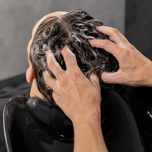 American Crew Daily Deep Moisturizing Shampoo massaged into wet hair at a salon basin