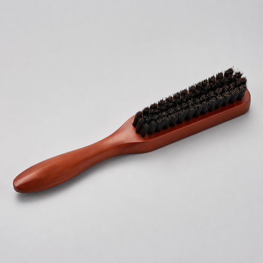 Flat wooden barber brush with black bristles on a light grey studio background