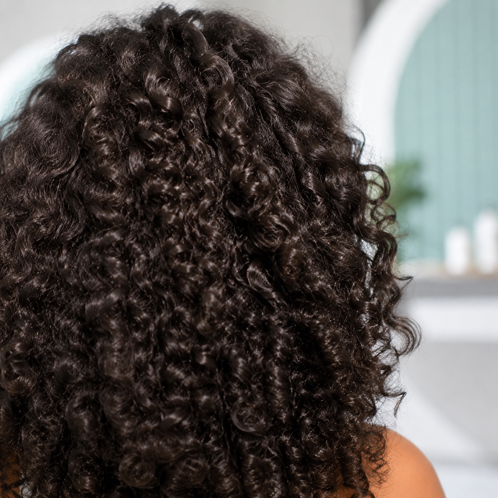 Close detail of naturally defined dark brown curls after a Curl Partner wellness treatment