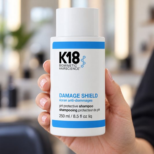 K18 Damage Shield Protective Shampoo 250ml held in a salon, with the product label visible.