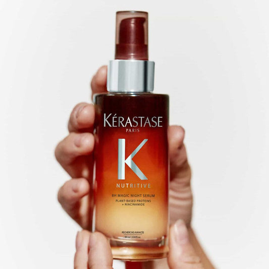 Hand holding a bottle of Kérastase Nutritive 8H Magic Night Serum