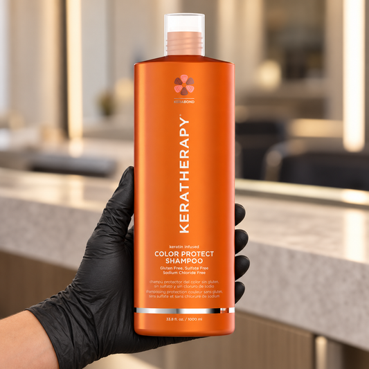 Keratherapy Keratin Infused Color Protect Shampoo 1L held upright in a gloved hand in a salon, with the front label visible.