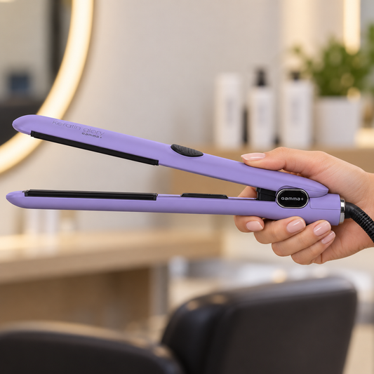 Lilac Gamma+ Keratin Glory straightener held by its handle in a salon, showing the open plates