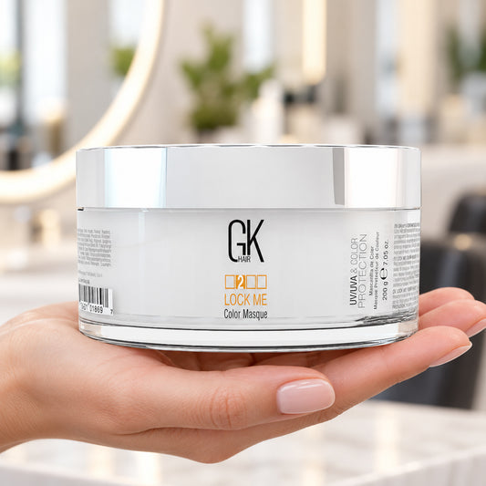 GK Hair Lock Me Color Masque 200g jar supported in a hand at a salon workstation