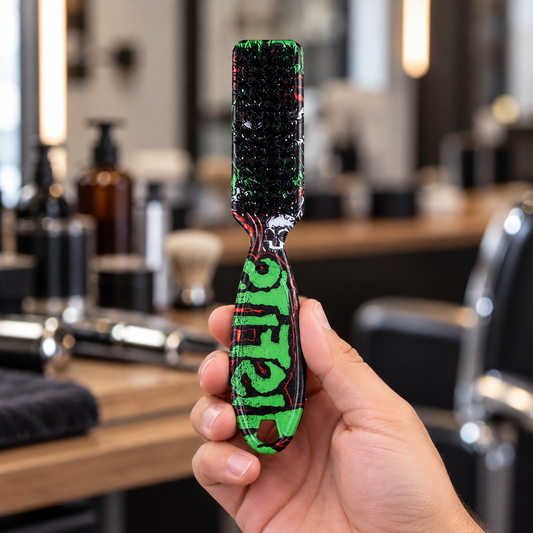 Green patterned MV Beard Grooming Brush held by its handle at a barber station.