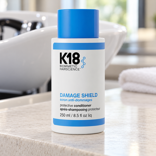 K18 Damage Shield Protective Conditioner 250ml beside a salon wash basin.