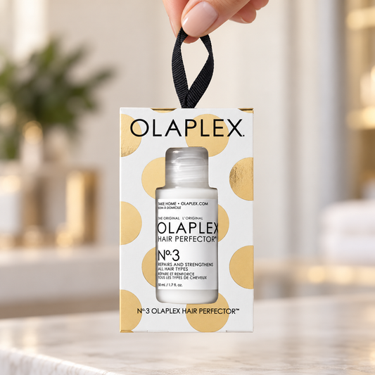 OLAPLEX No.3 Hair Perfector 50ml holiday ornament held by its black hanging loop.