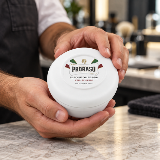 Proraso Shave Soap Mug Sensitive held at a barber station, showing its original container.
