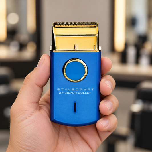 Blue StyleCraft by Silver Bullet Uno shaver held in a hand, showing the gold foil and circular control.