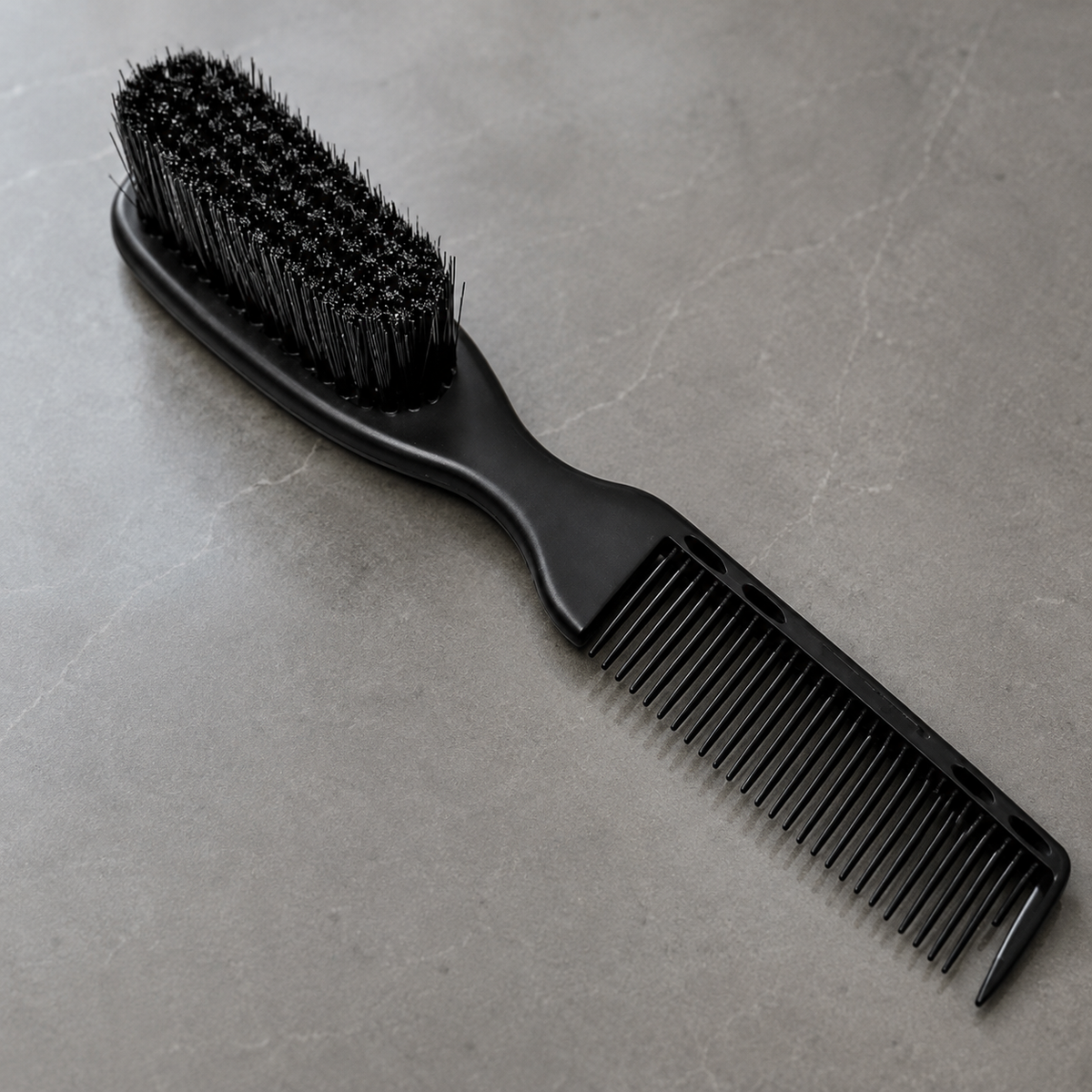 Close detail of black 2-in-1 fade brush bristles, fine comb teeth and pointed tail