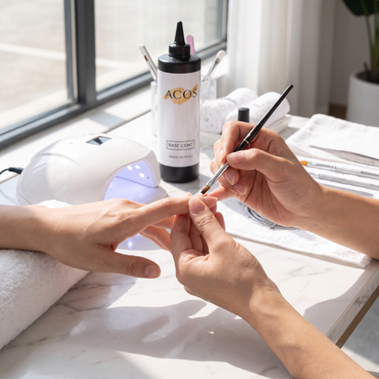 Nail technician applying ACOS Gel Base Coat