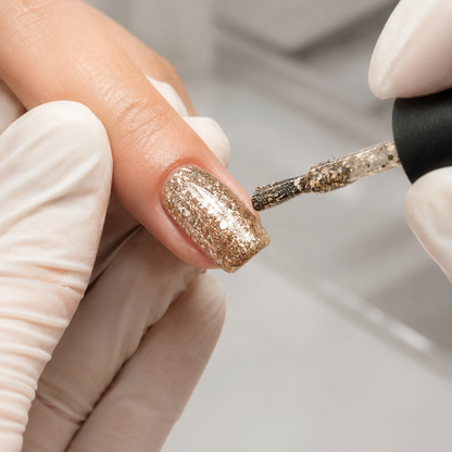 Nail technician applying ACOS Glitter Gold 040 gel polish