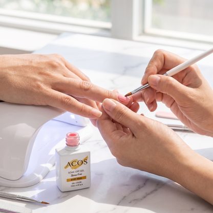 Nail technician applying ACOS Baby Pink gel
