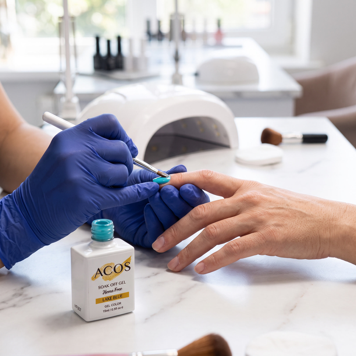 Nail technician applying ACOS Lake Blue gel