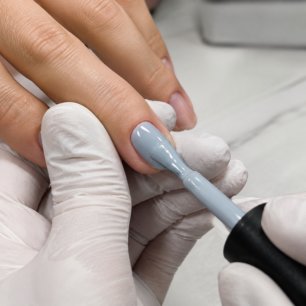 Professional applying ACOS Light Grey Blue 068 gel colour to a prepared fingernail