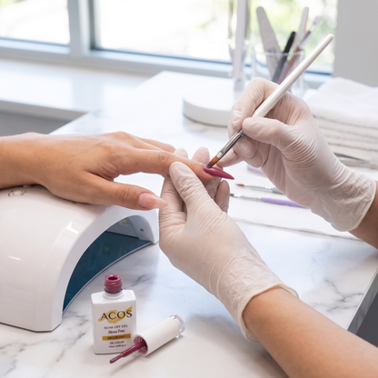 Nail technician applying ACOS Mulberry 017 gel colour