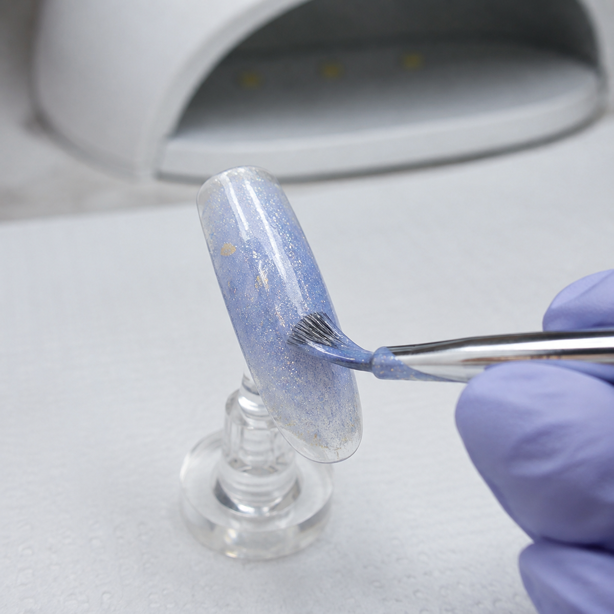 ACOS HF090 glitter-blue gel applied to an artificial nail tip