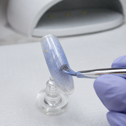 ACOS HF090 glitter-blue gel applied to an artificial nail tip