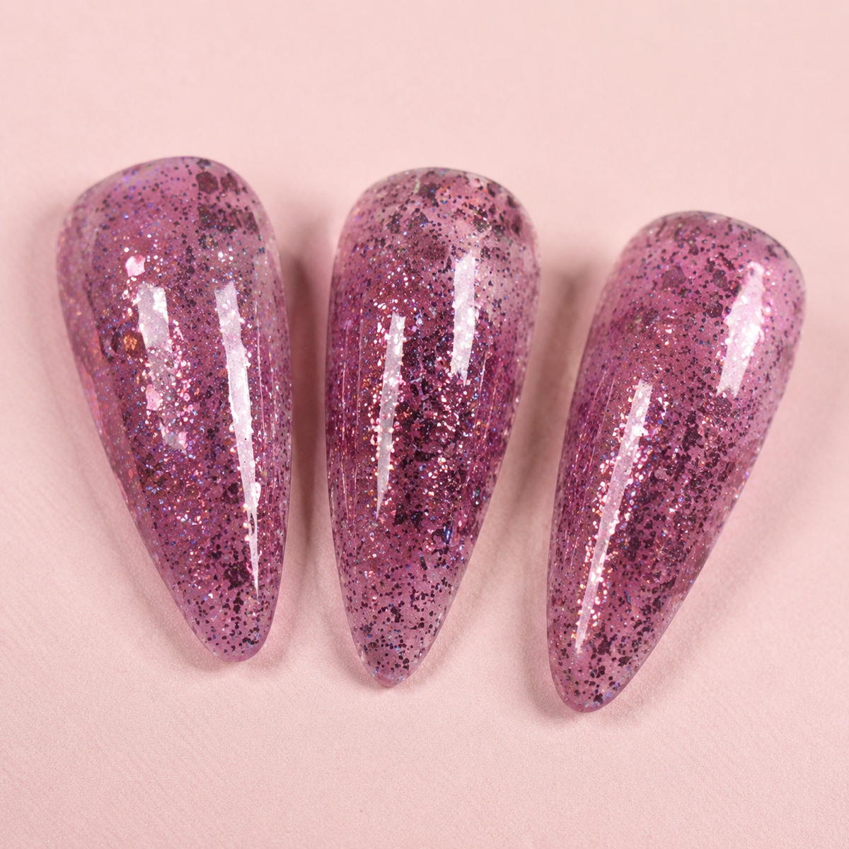 Three cured artificial nail tips showing the glossy ACOS HF094 Glitter Dark Pink result.