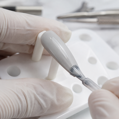 Professional applying ACOS Light Grey 037 gel colour to an artificial practice tip