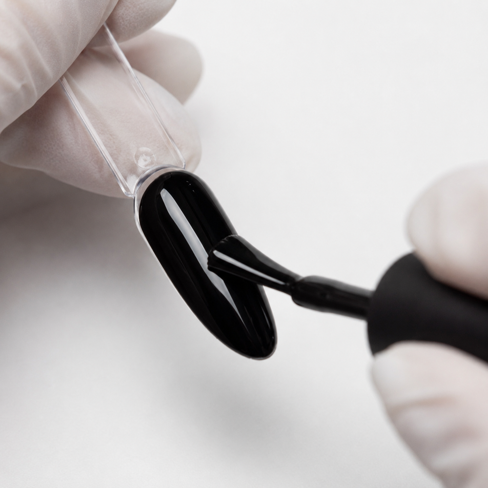 Professional applying ACOS HF098 Super Black gel colour to an almond swatch