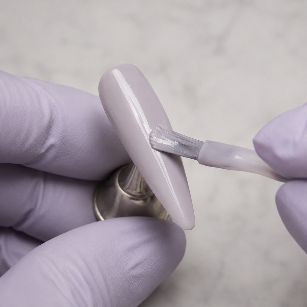 Professional application of ACOS HF077 Milky Purple Clay gel to an artificial nail tip
