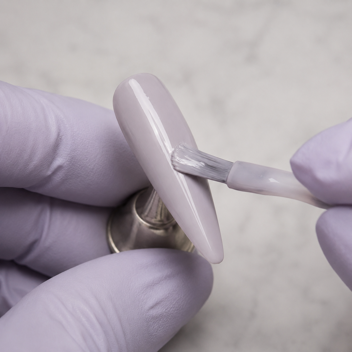 Professional application of ACOS HF077 Milky Purple Clay gel to an artificial nail tip