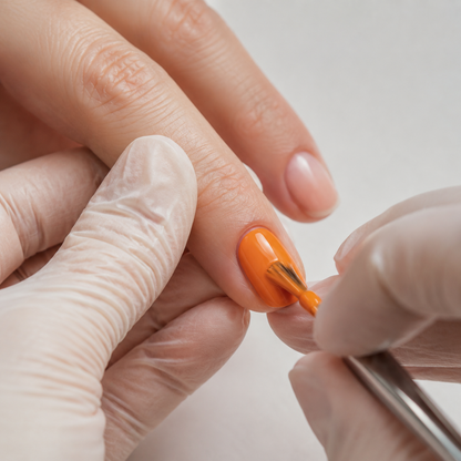 Professional applying ACOS Bright Orange 065 gel polish to a prepared nail