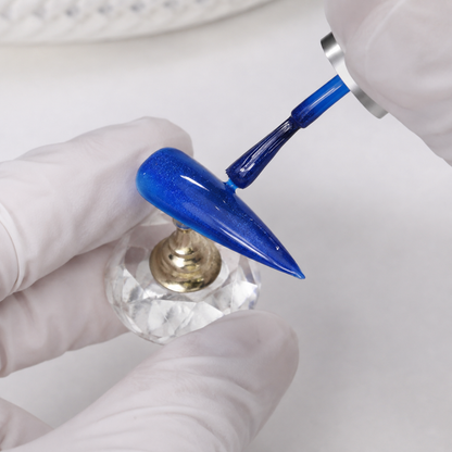 Professional applying ACOS Glossy Blue 100 gel to an artificial nail tip
