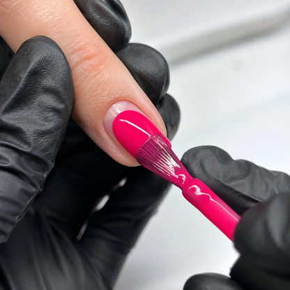 Professional applying Hot Pink 008 gel polish to a prepared fingernail