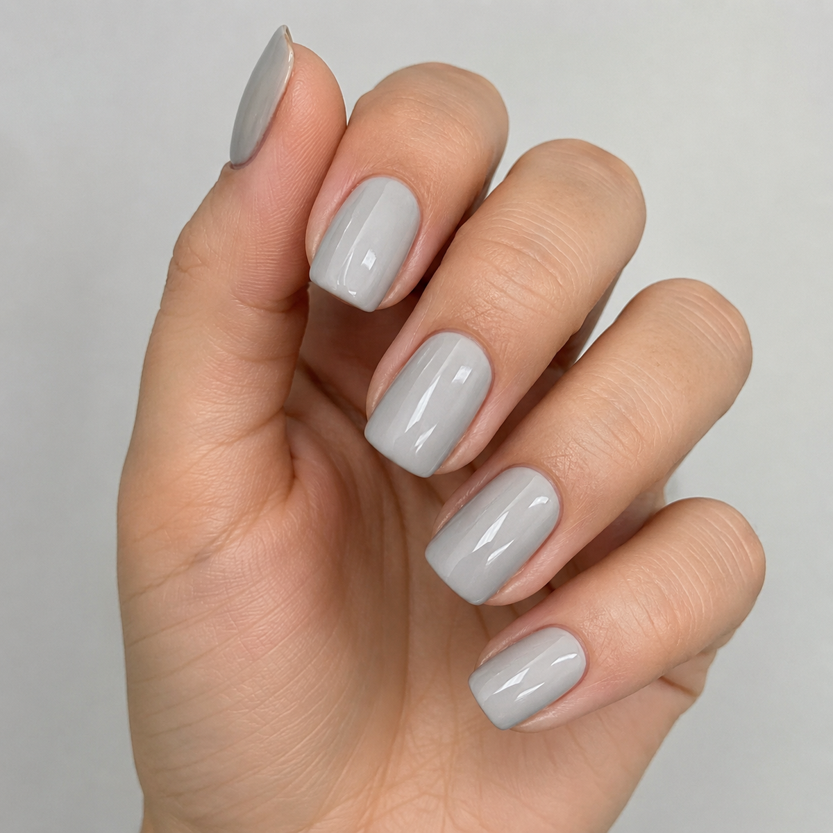 Finished glossy light grey gel manicure with smooth salon-quality coverage