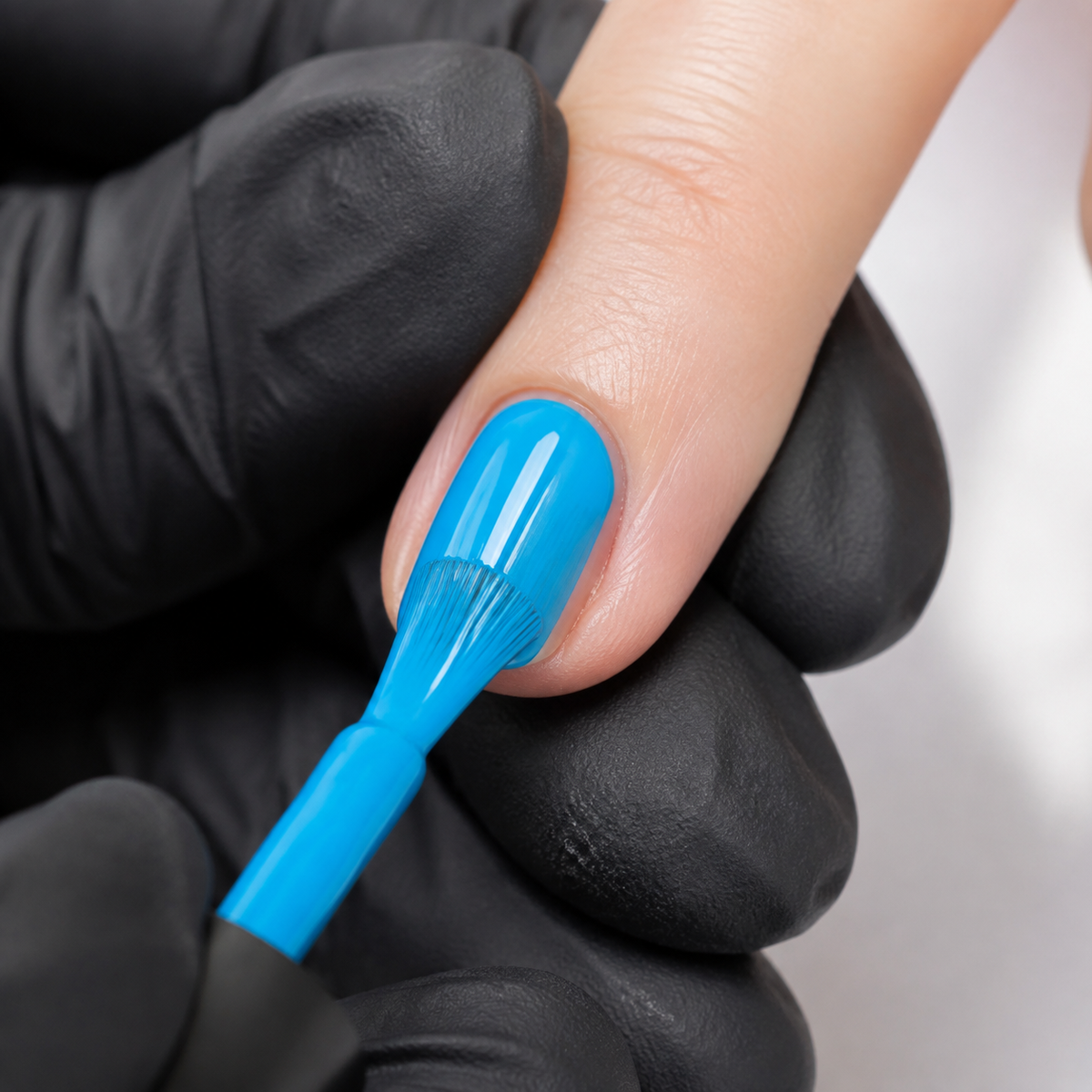 Professional applying Light Peacock Blue 029 gel polish to a prepared fingernail