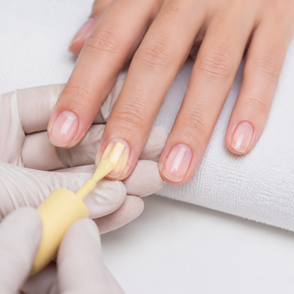 Professional applying ACOS Milky Yellow 043 gel polish to an adult fingernail