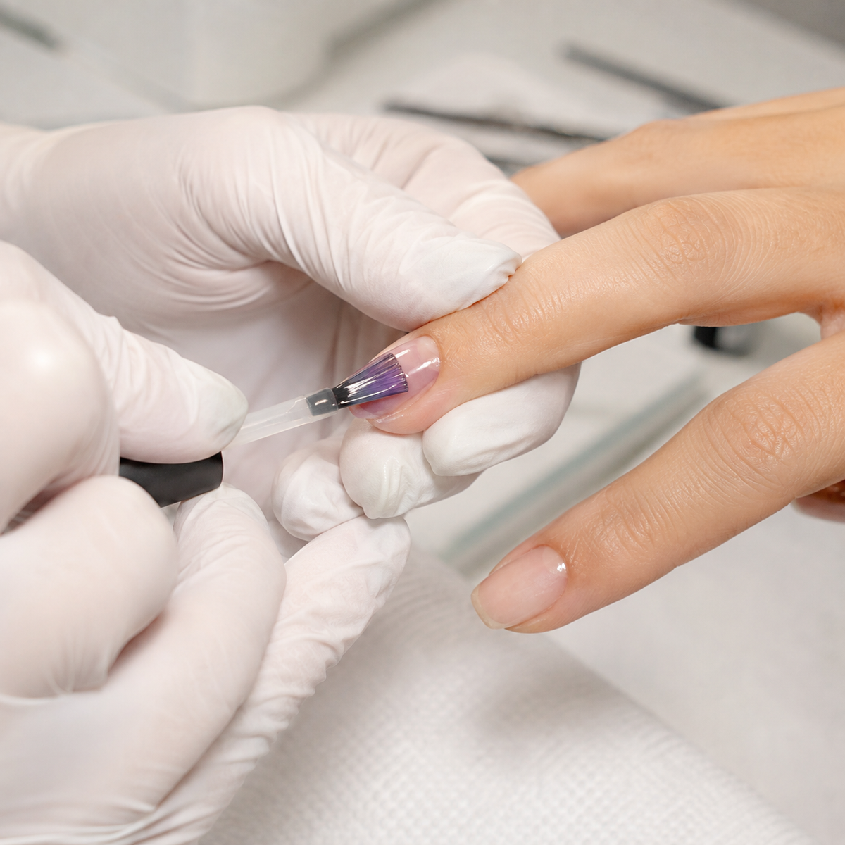 Professional applying ACOS Transparent Grape 090 gel polish