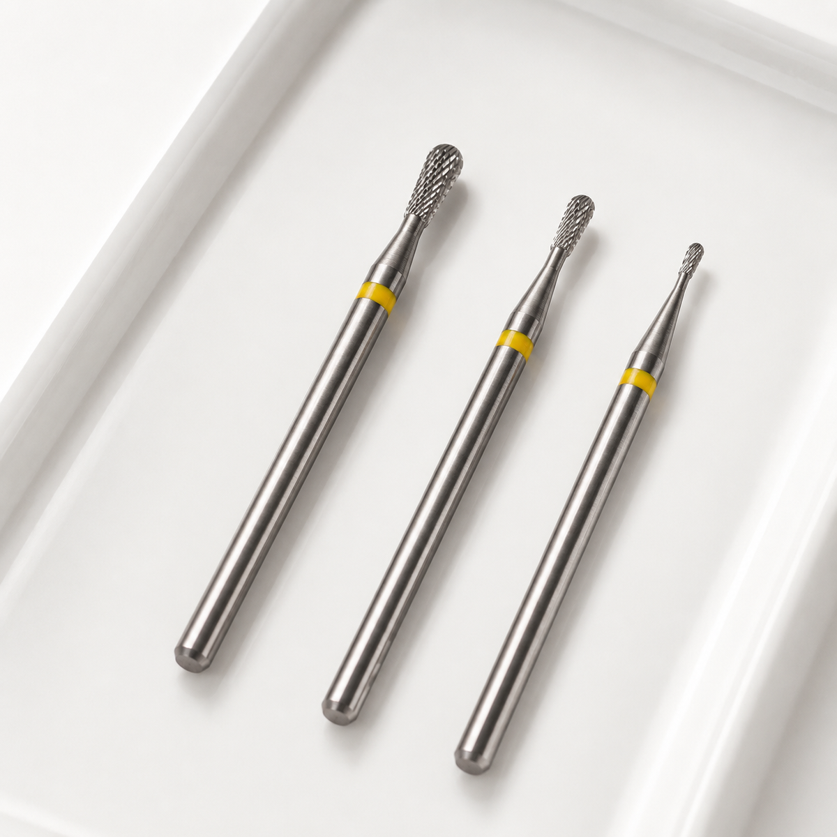 Three ACOS pear-shaped nail drill bit sizes with yellow bands and straight silver shanks