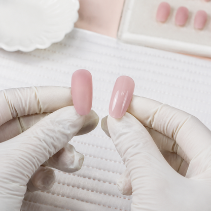 Gloved nail professional comparing matte-buffed and glossy artificial practice nail tips