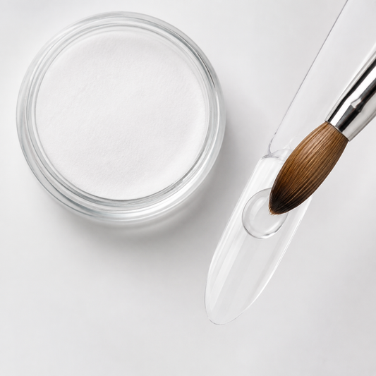 Clear AEON acrylic powder sample with brush forming a transparent bead on a practice nail