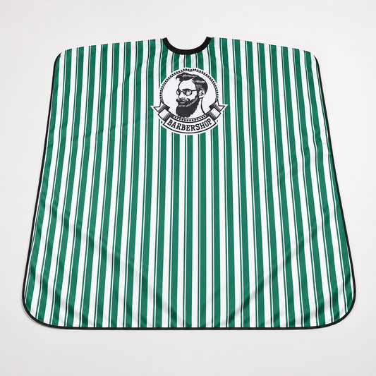 Green and white striped Barbershop cape laid flat on a light studio background