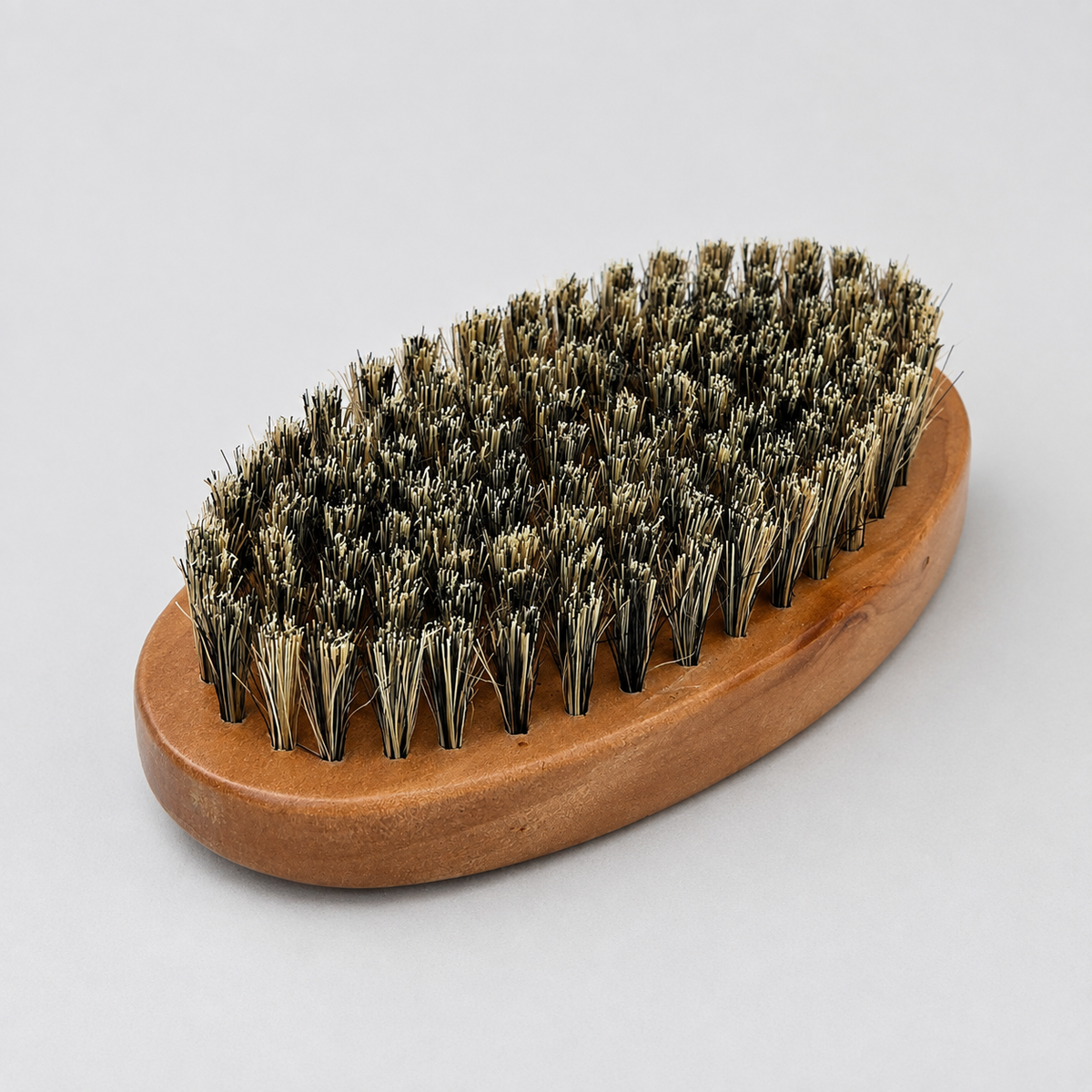 Oval wooden fade brush with dense mixed-colour bristles