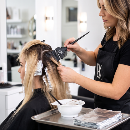 Colourist applying hair colour with GK brush comb