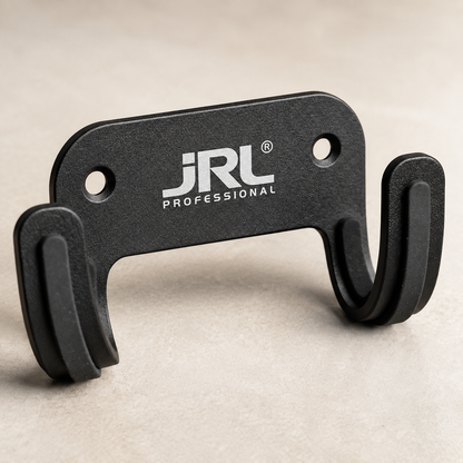 Close view of the black JRL blow dryer holder showing its white logo, two mounting holes and padded cradle