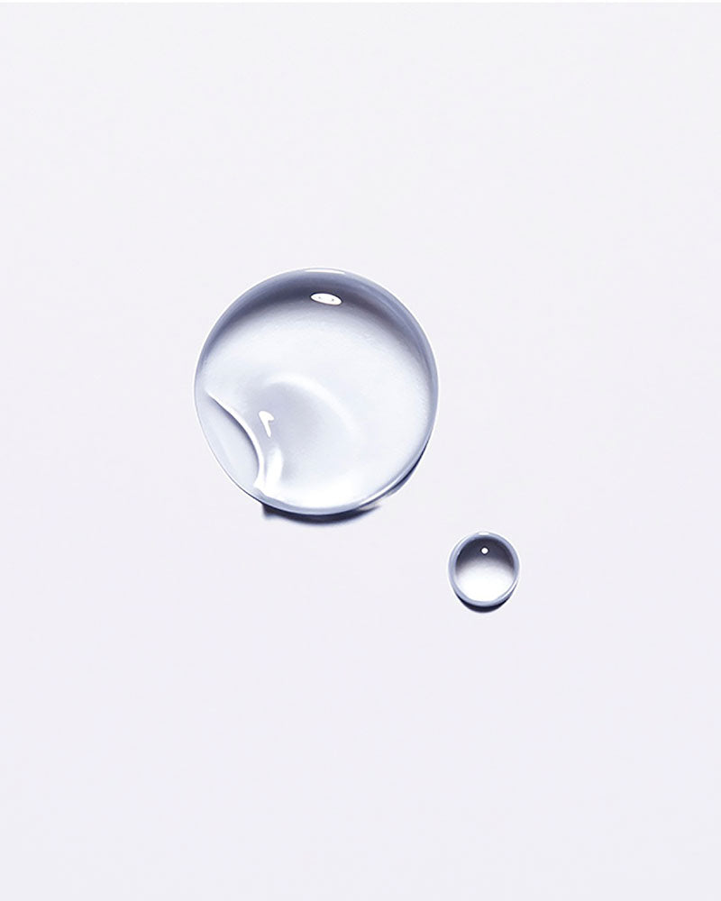 Clear droplet of Kérastase Chronologiste hair oil on a white background