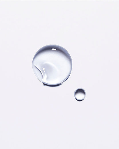Clear droplet of Kérastase Chronologiste hair oil on a white background