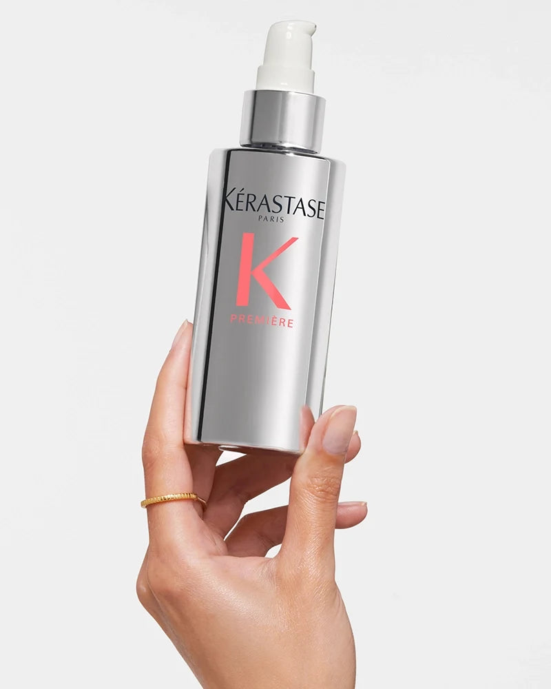 Hand holding a bottle of Kérastase Première Sérum Filler Fondamental