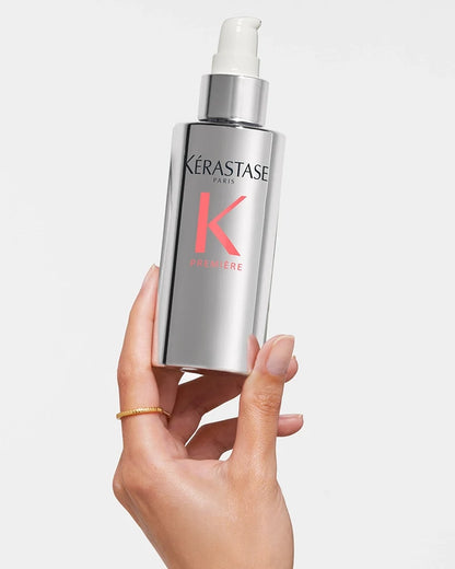 Hand holding a bottle of Kérastase Première Sérum Filler Fondamental