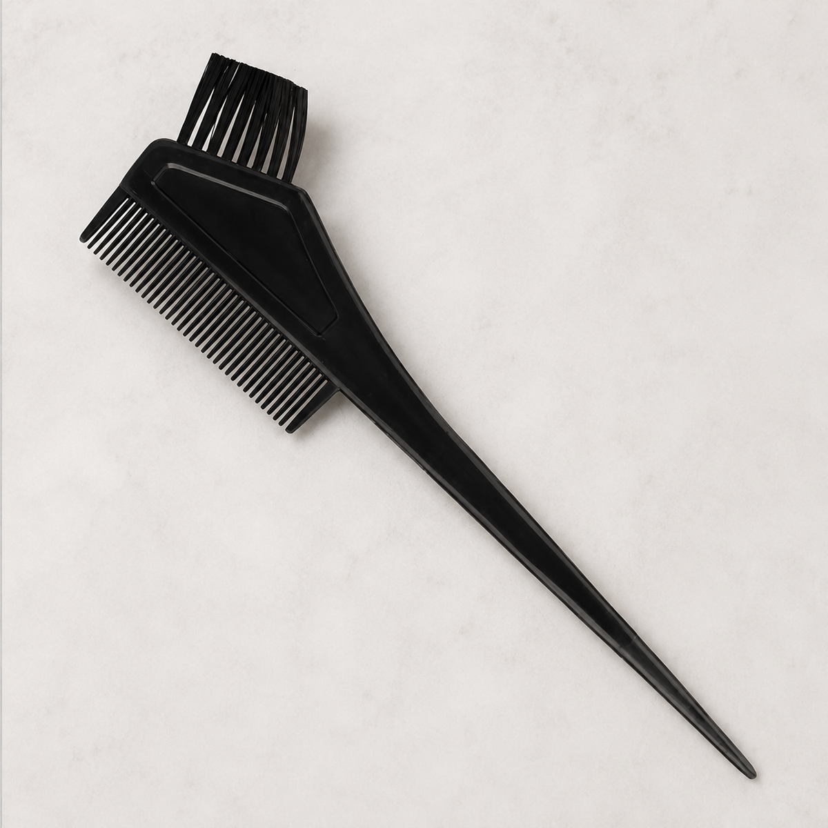 Close view of black HS tint brush with comb, bristles and pointed sectioning tail