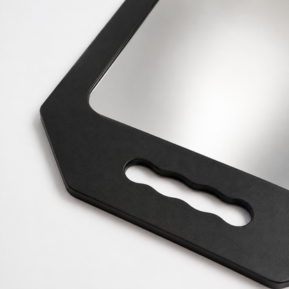 Close detail of the black mirror frame, rounded glass edge and wavy grip opening