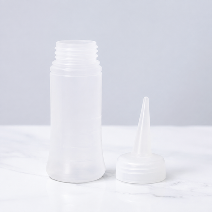 Translucent liquid applicator bottle with removable screw-on long nozzle cap