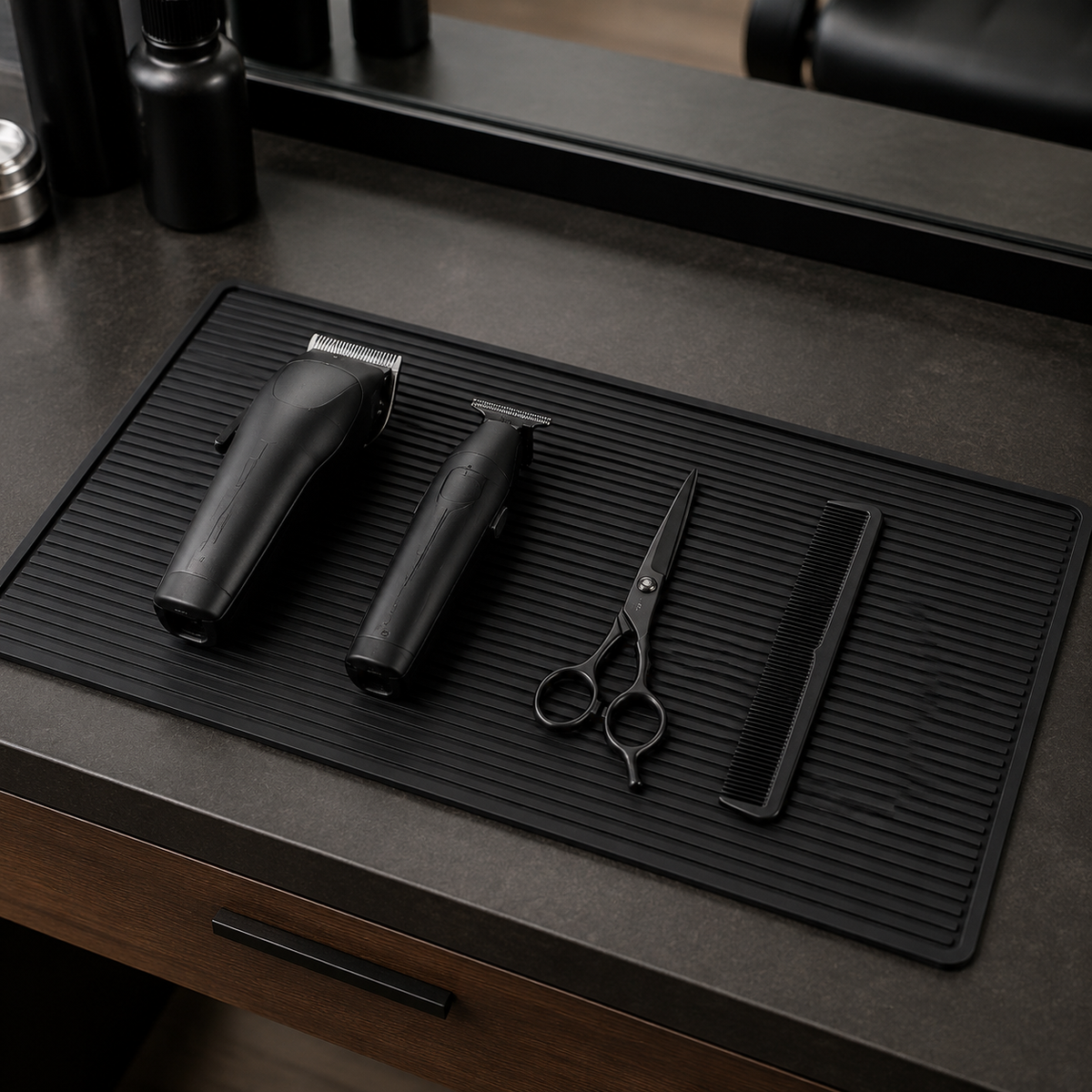 Black grooved barber mat holding switched-off clippers, scissors and comb