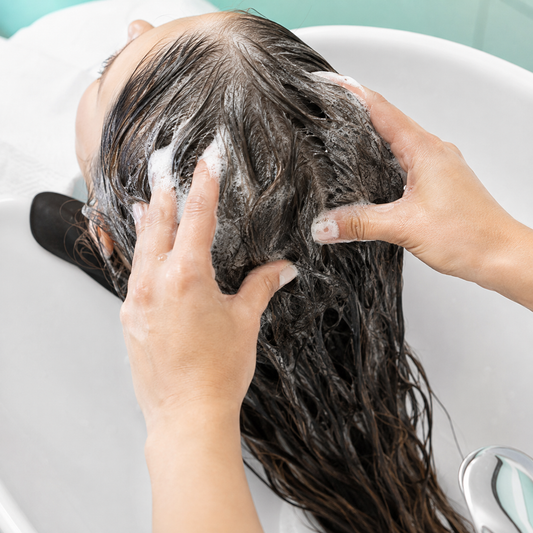 Malibu C Scalp Wellness Shampoo massaged through wet hair at a salon basin